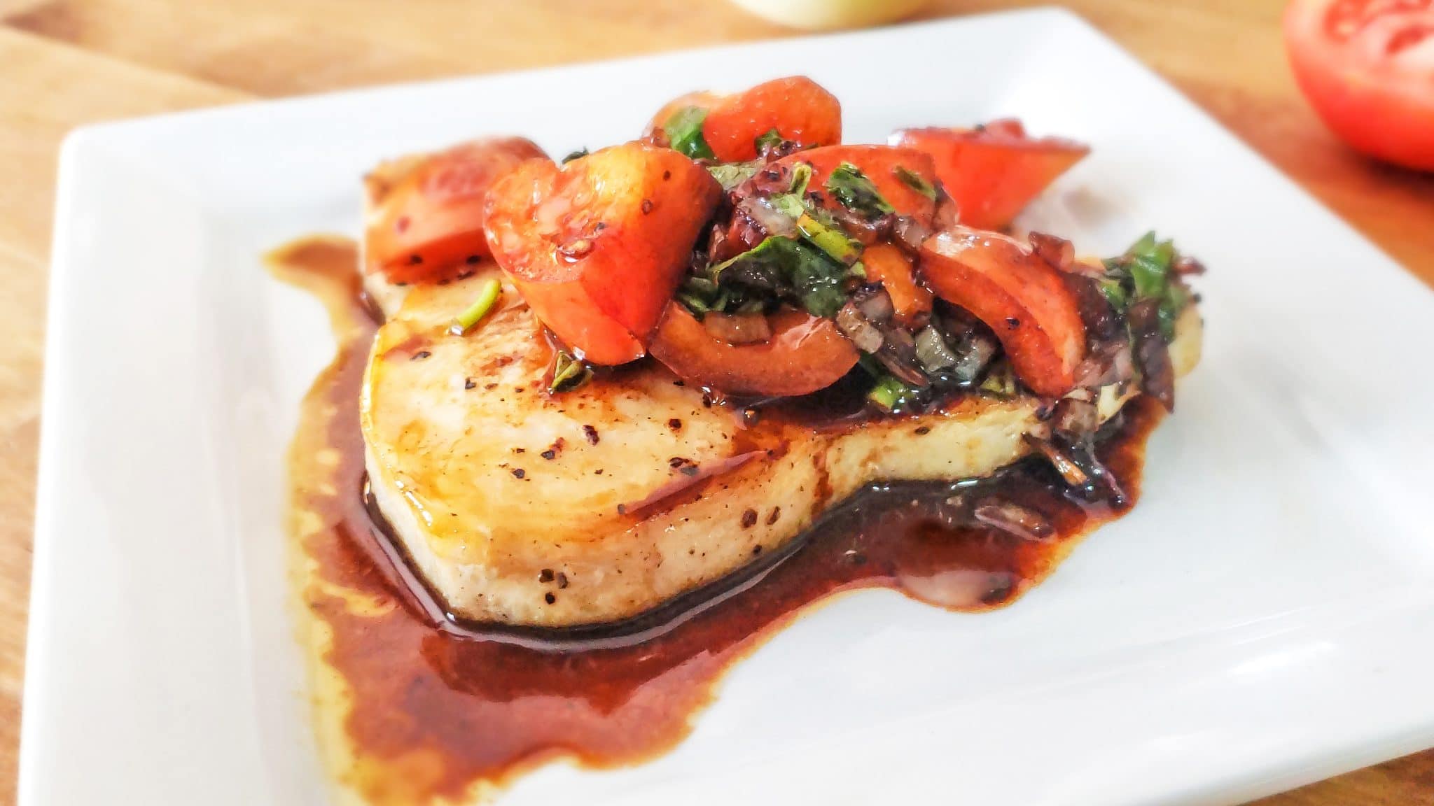 balsamic glazed swordfish with tomatoes and basil plated